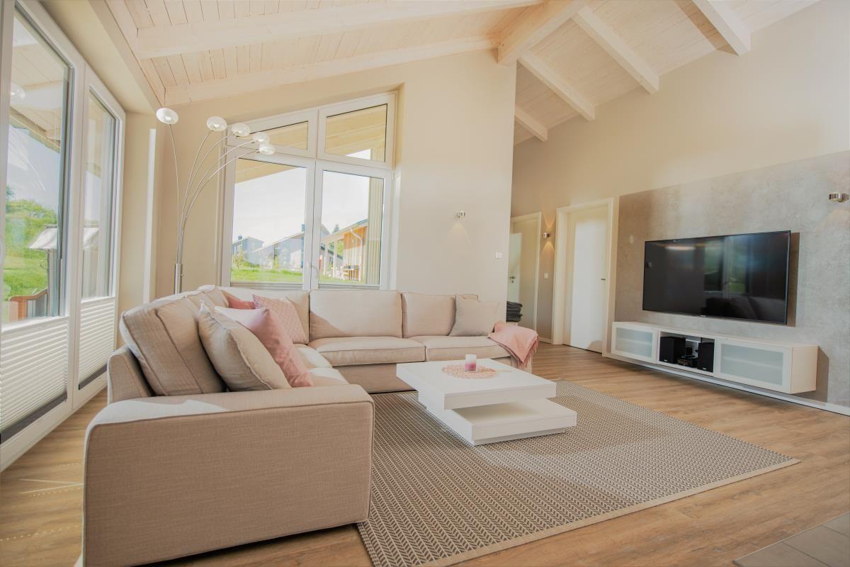 Wohnzimmer mit Sofa, Couchtisch und Fernseher an der Wand.