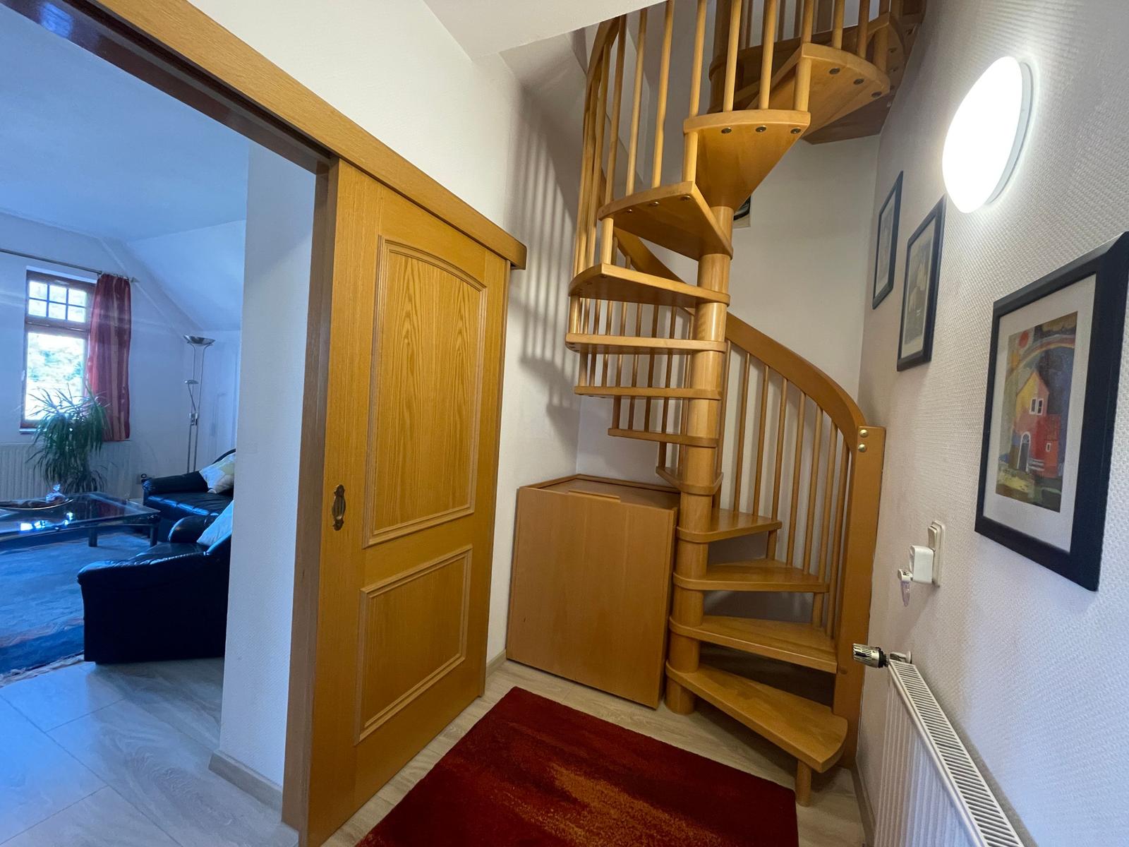 Großzügiger Flur mit Garderobe und Wendeltreppe zum Schlafzimmer.
