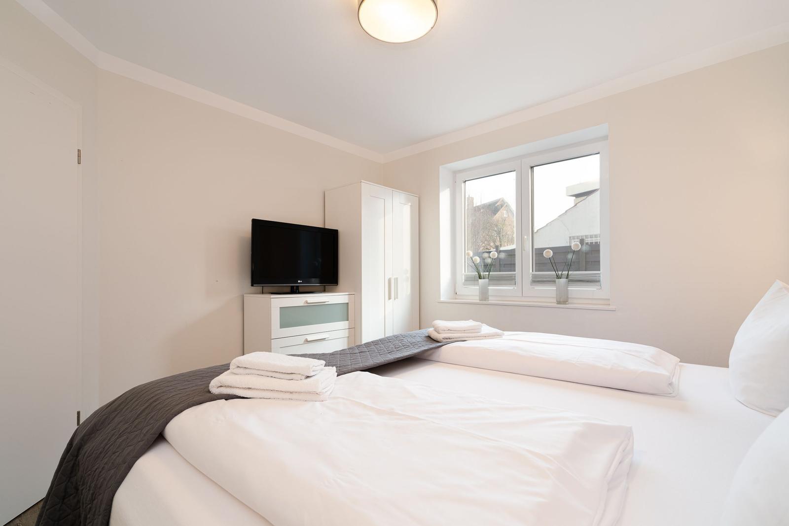 Bedroom with bed, TV, and window