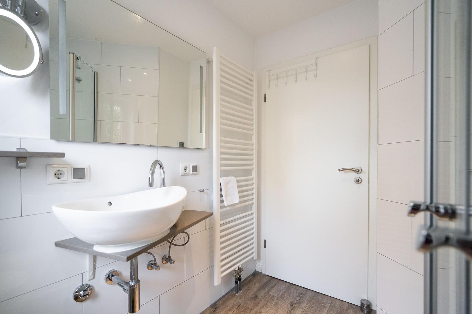 Bathroom with sink, mirror, and heater