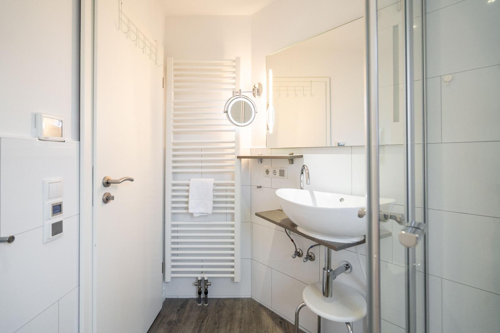 Bathroom with shower, sink, and heater