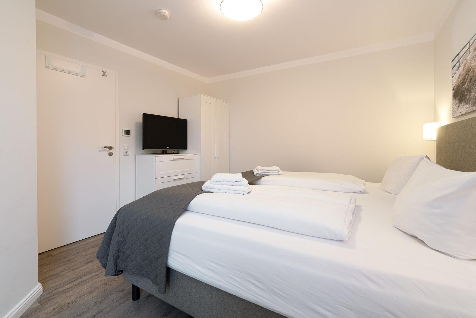 Bedroom with bed, TV, and wardrobe.