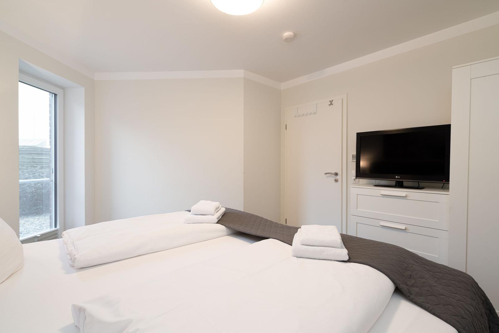 Bedroom with bed, TV, and window.