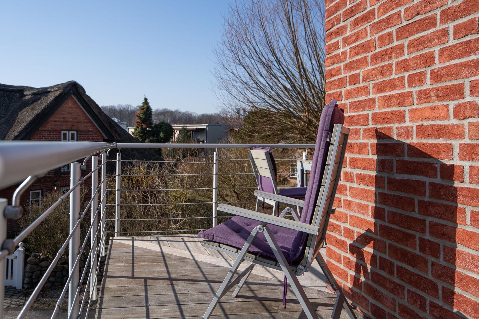 Terrasse mit zwei Stühlen und Blick auf das Gelände.