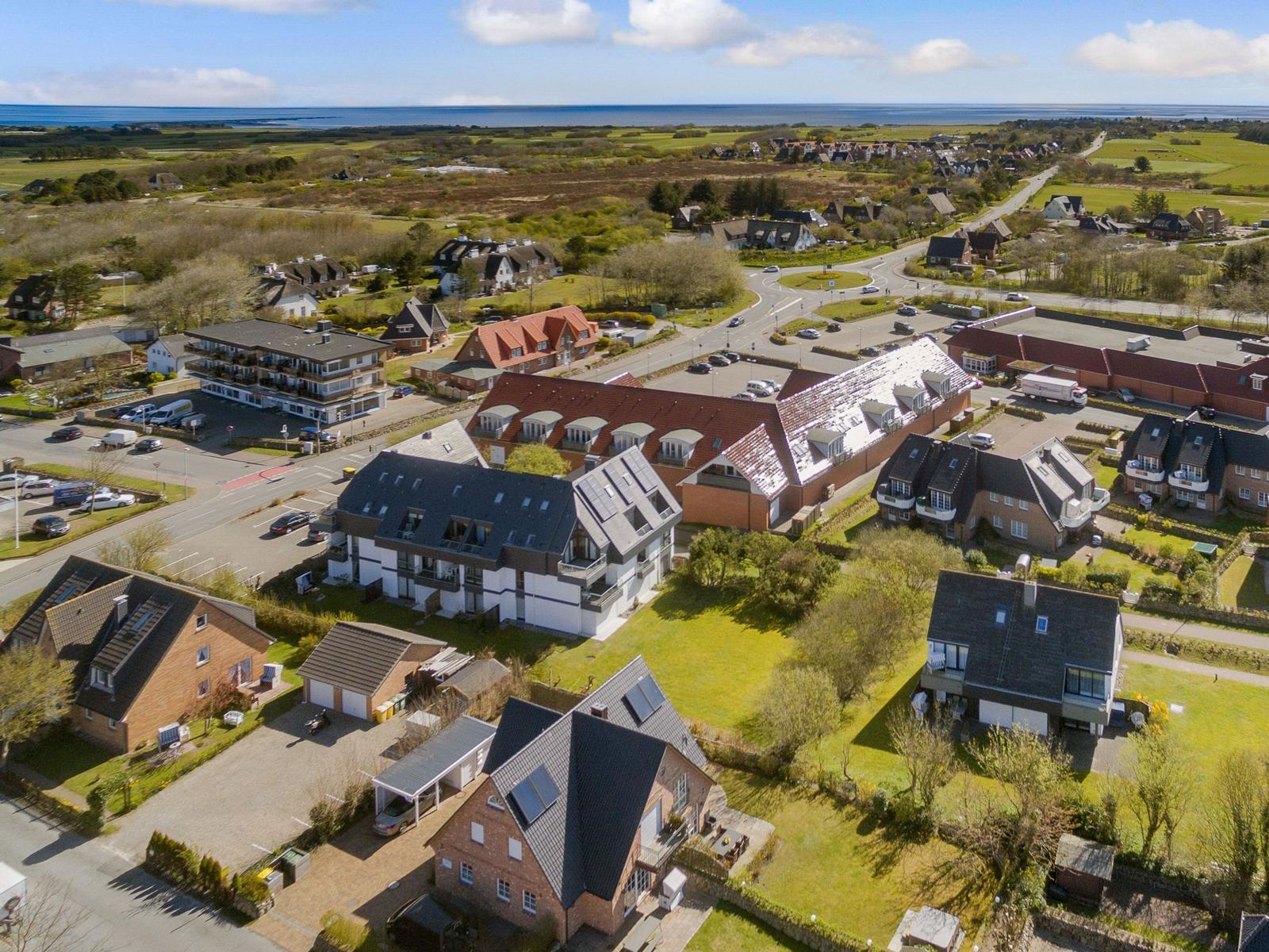 Luftbild von Wohnhäusern mit Grünflächen und Blick auf die Nordsee.