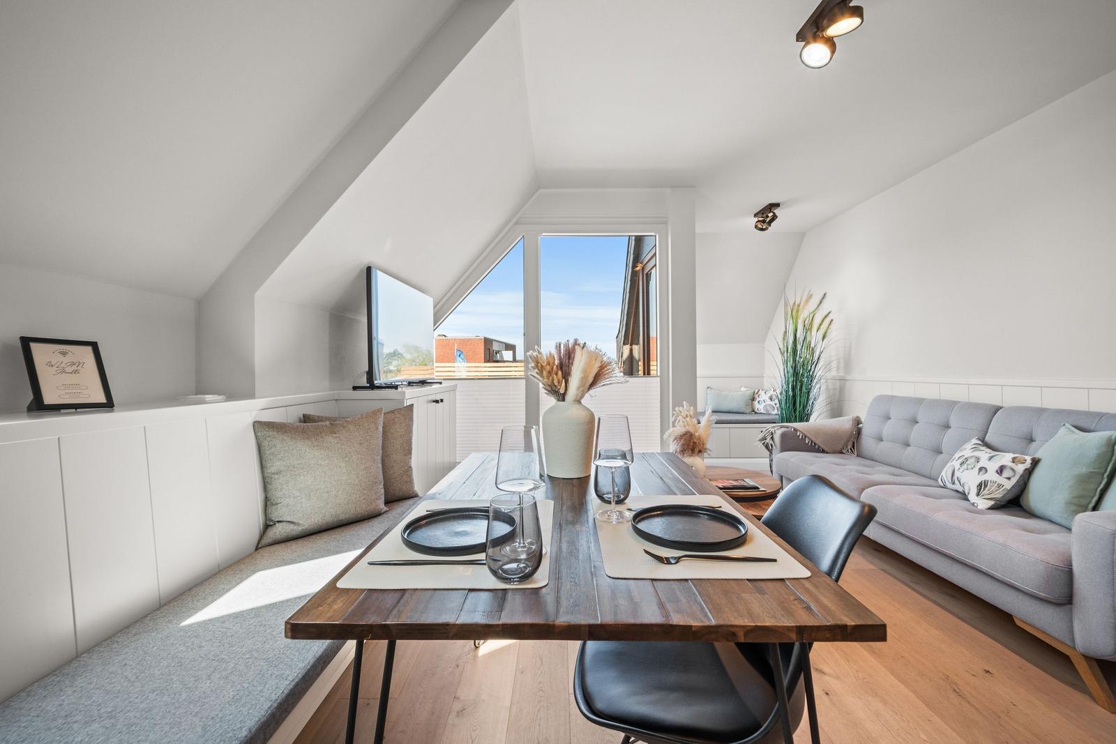 Essbereich mit Tisch und Stühlen, Sofa und Fenster mit Blick.