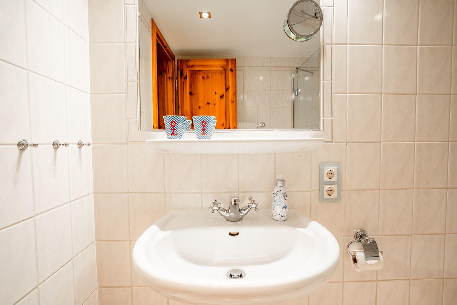 Bad mit Waschbecken, Spiegel und Dusche