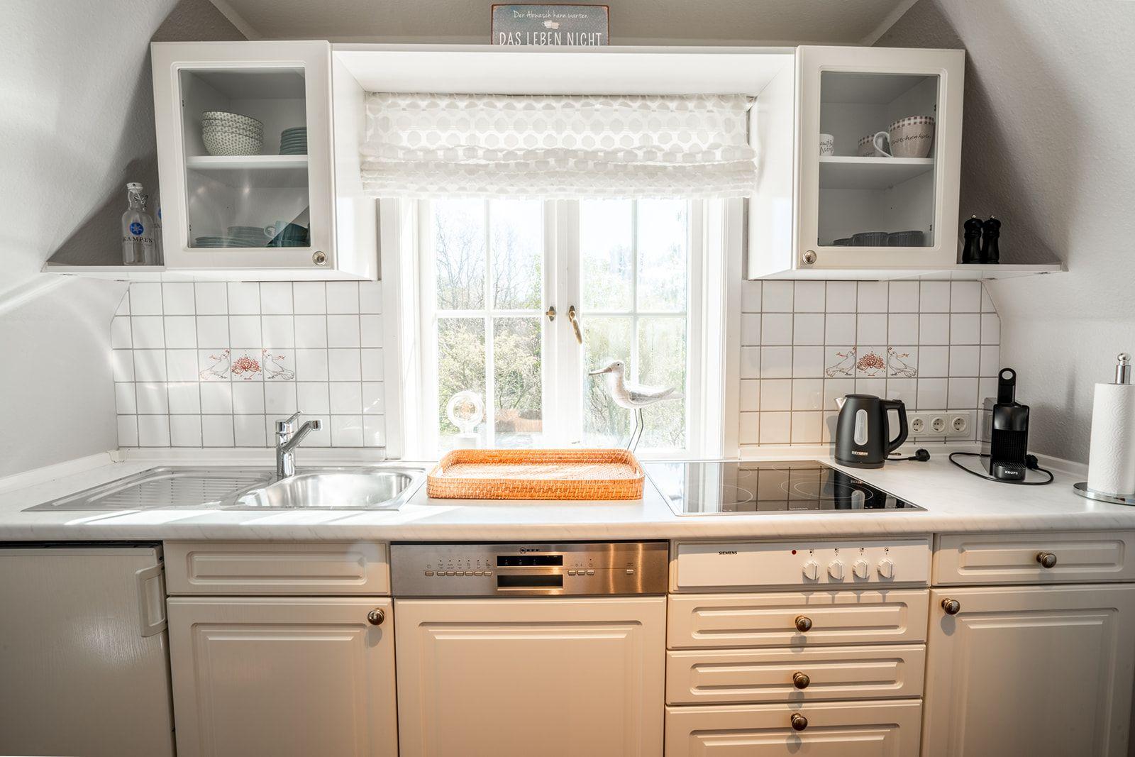 Küche mit Fenster, Spüle, Herd und Schränken