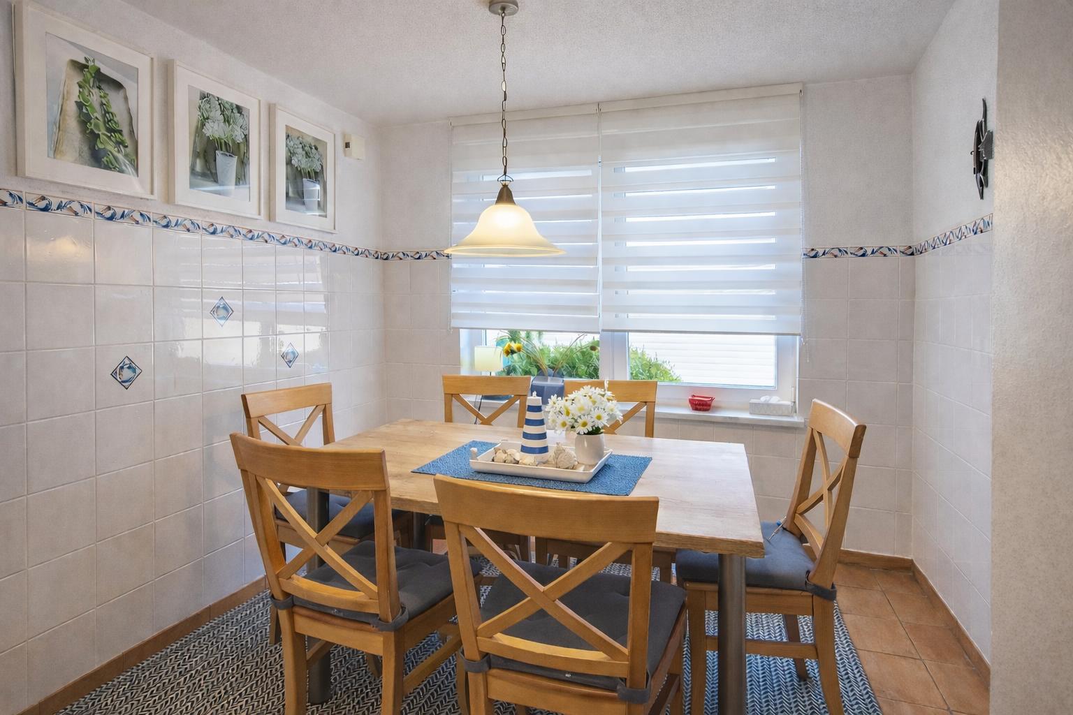 Esszimmer mit Holztisch, Stühlen und Fenster mit Jalousie.