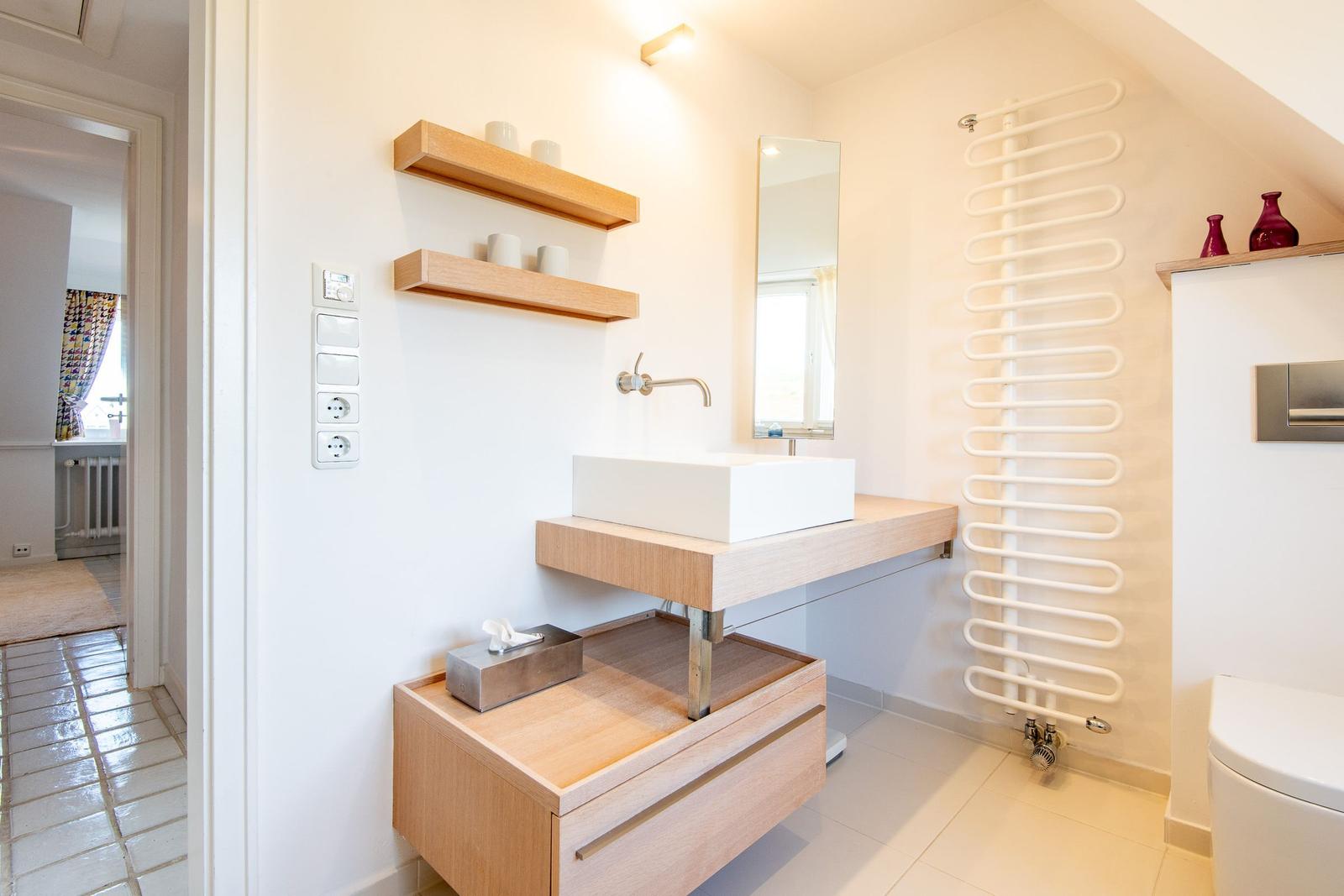 Bathroom with sink, mirror, and radiator