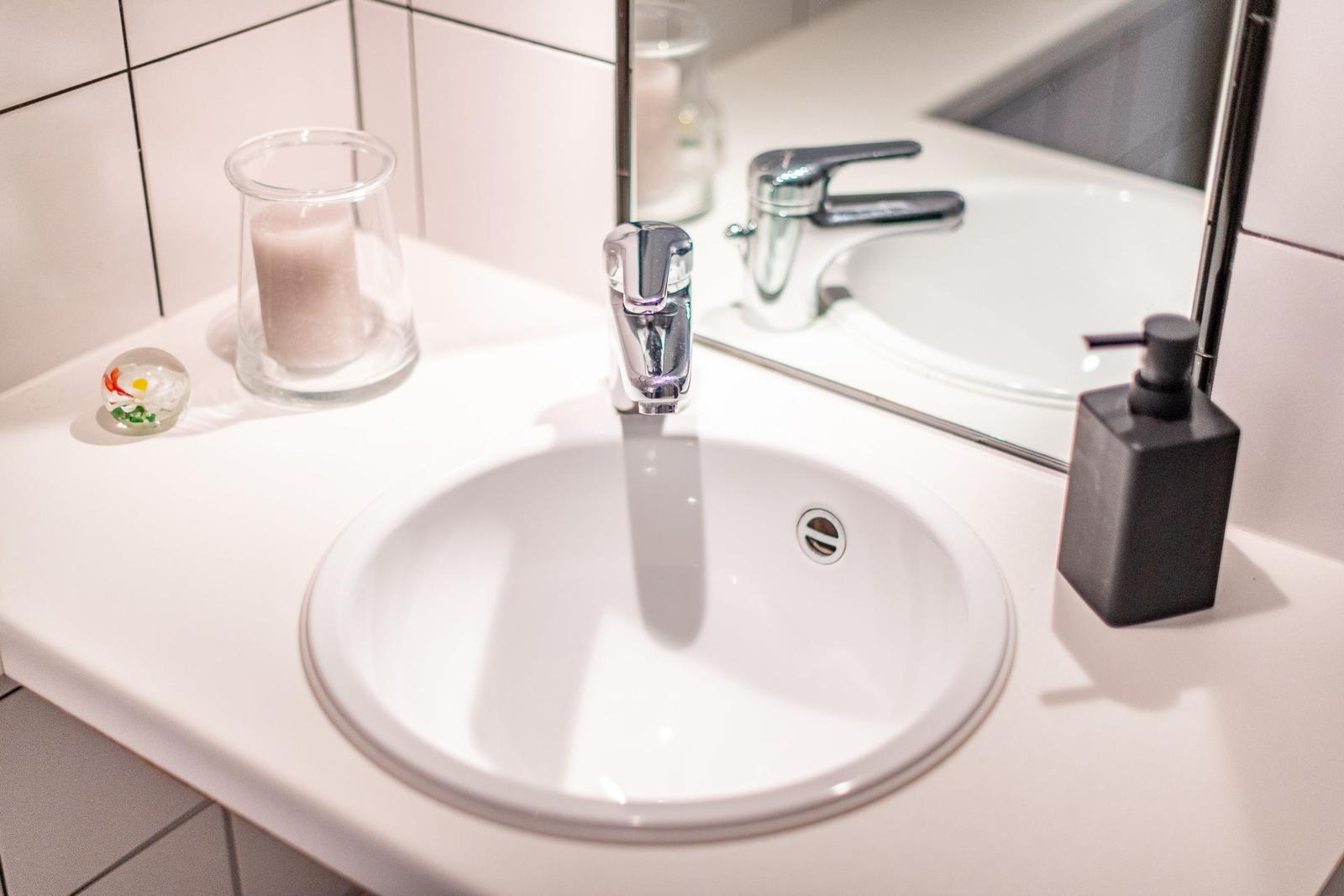 Sink with mirror, faucet, and soap