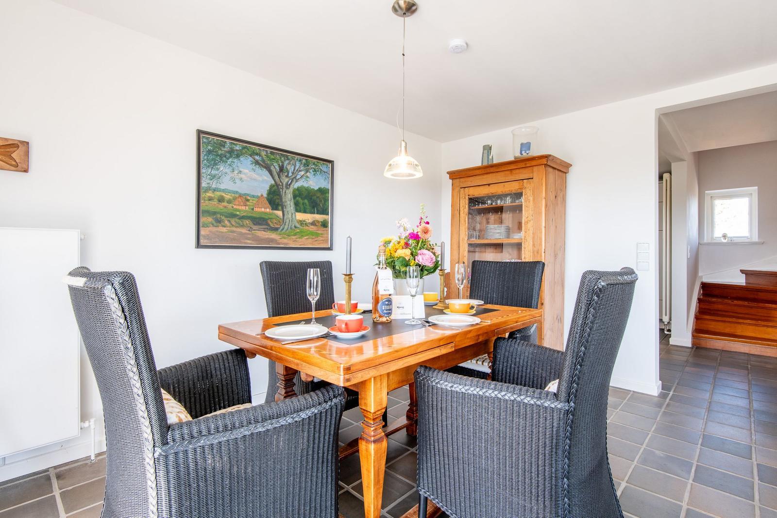 Dining table with six chairs and wooden cabinet against the wall.