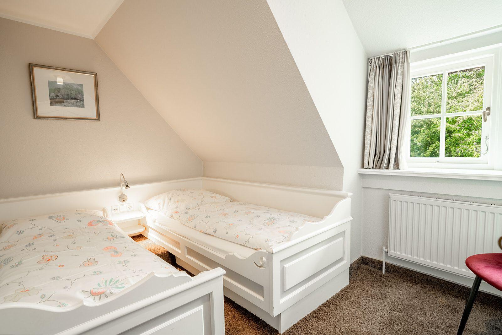 Schlafzimmer mit zwei Einzelbetten und Blick ins Grüne