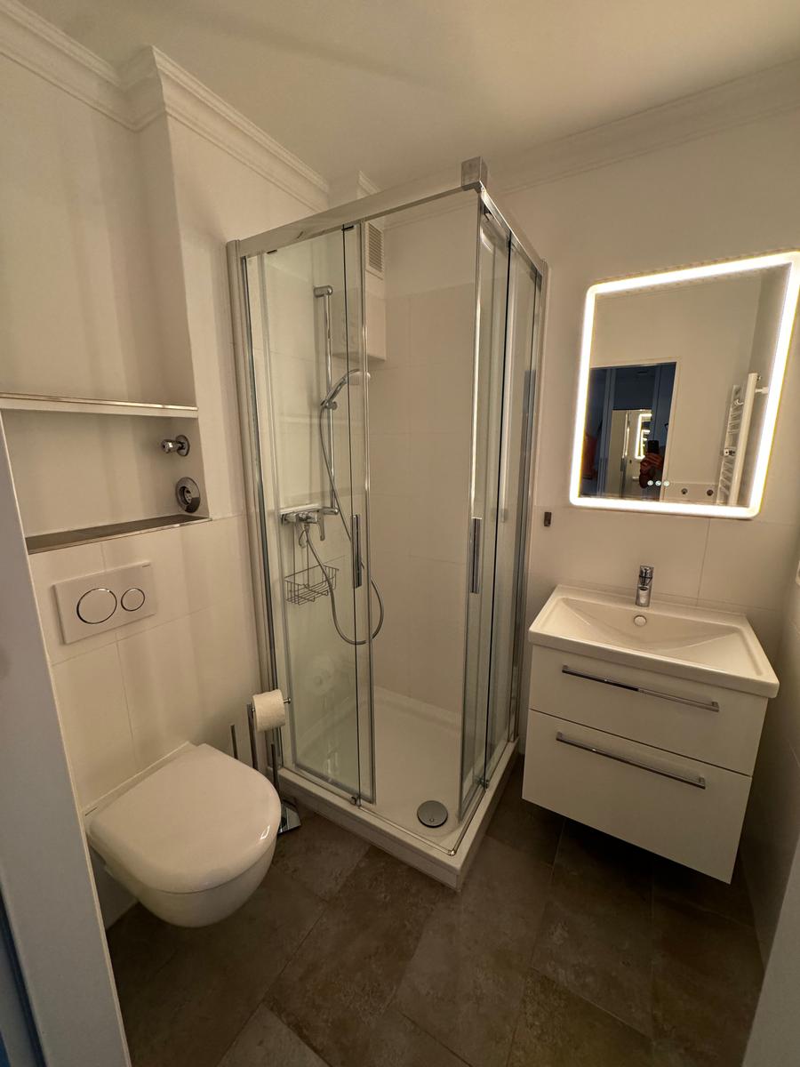 Badezimmer mit Dusche, Waschbecken und Toilette