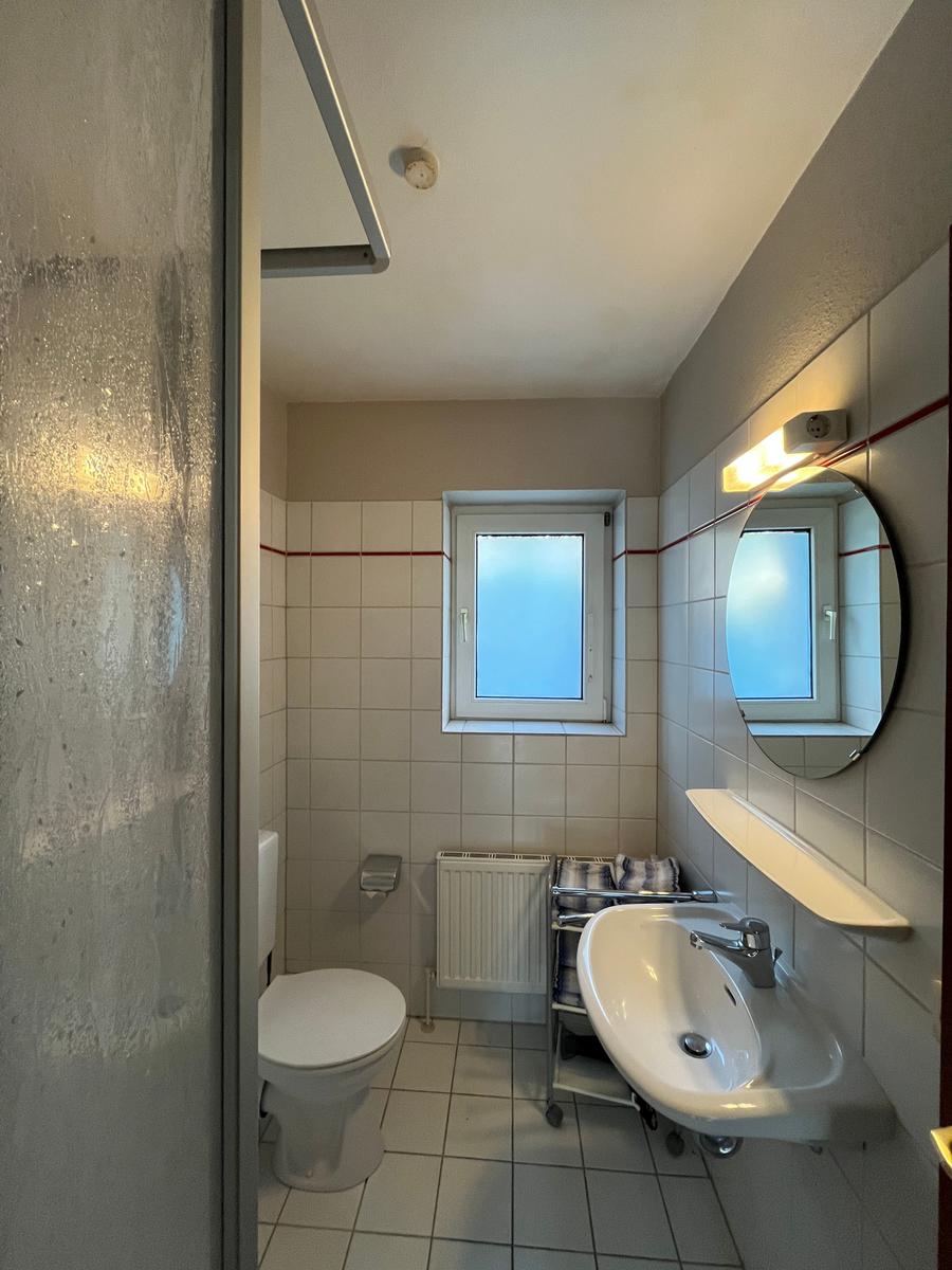 Badezimmer mit Dusche, Toilette und Waschbecken