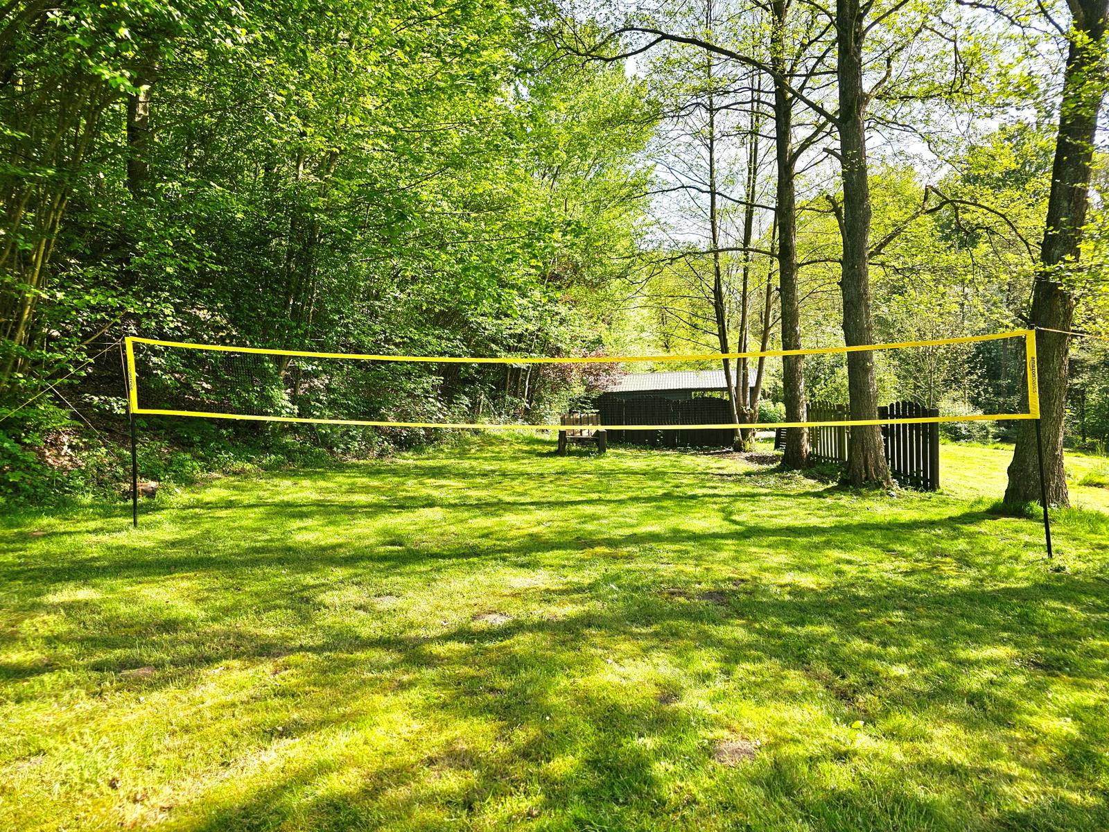 Volleyballnetz im grünen Garten zwischen Bäumen