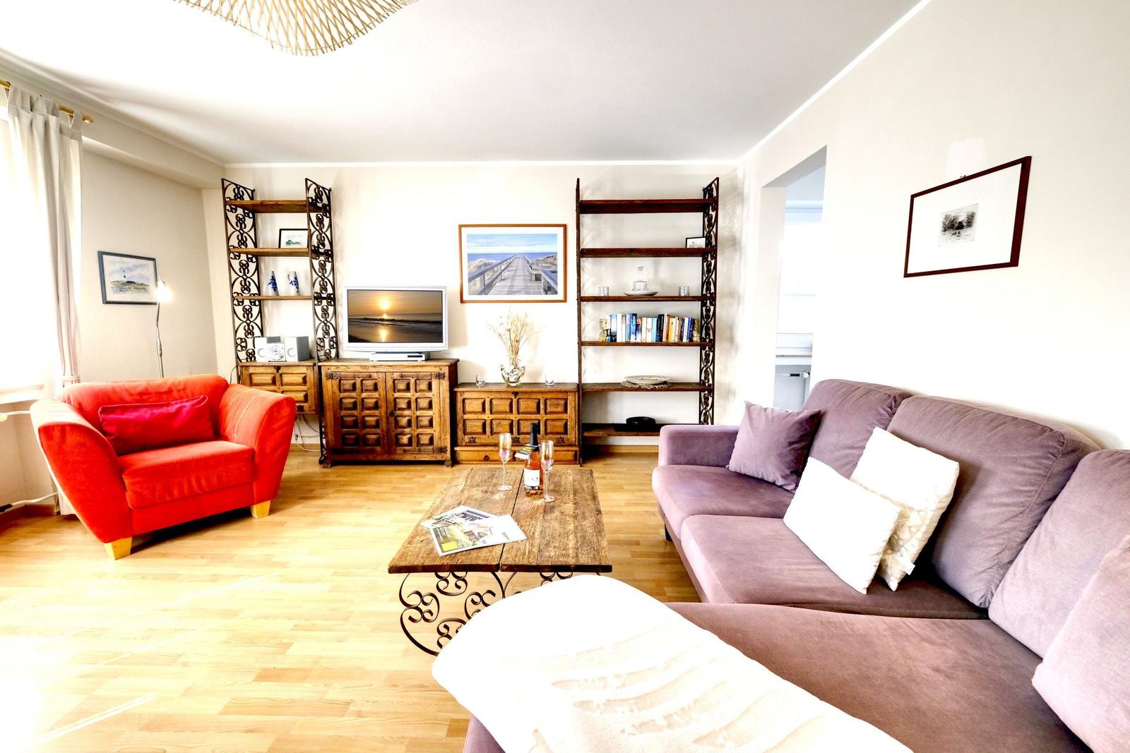 Living room with sofa, armchair, coffee table, and TV.