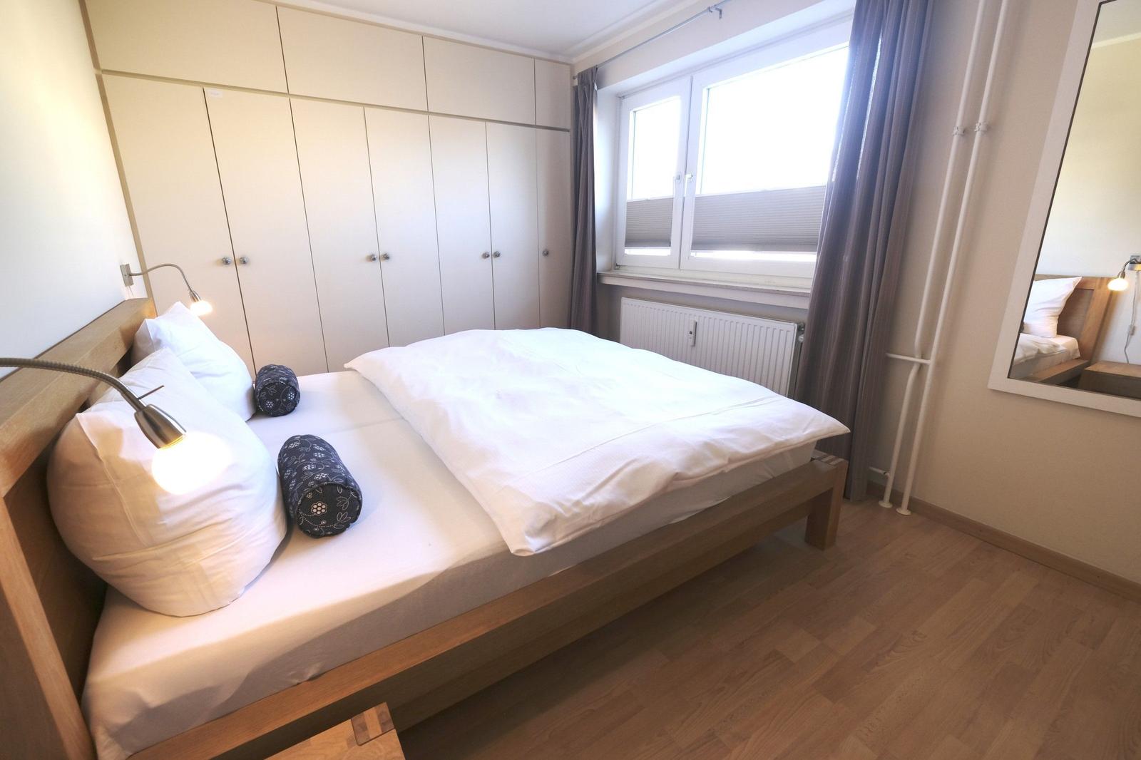 Bedroom with bed, closet, and window.