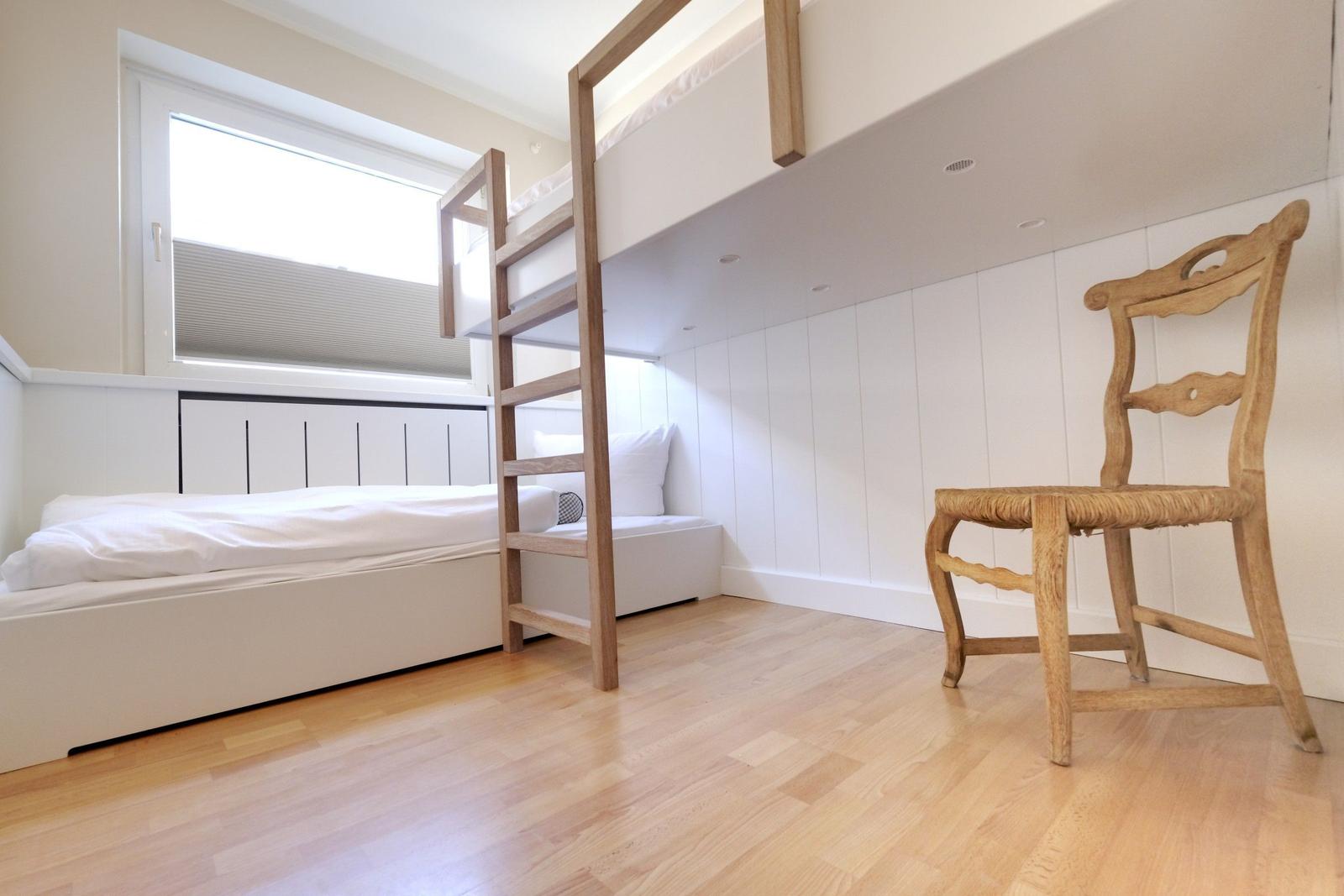 Bedroom with double bed, wooden chair, and window