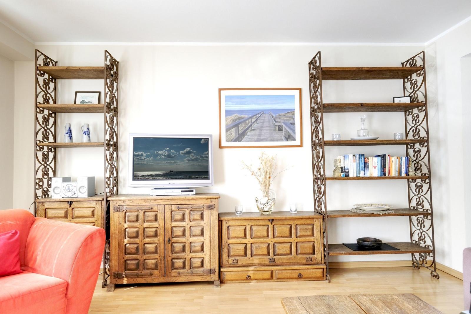 Living room with wooden furniture, TV, and bookshelves.