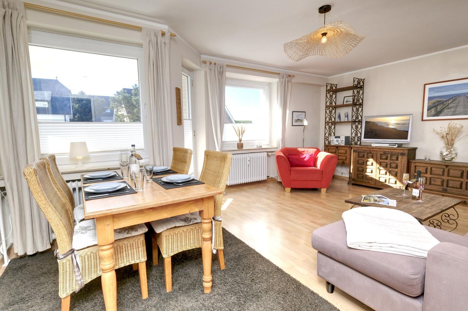 Dining area with table and chairs, living area with sofa and armchair.