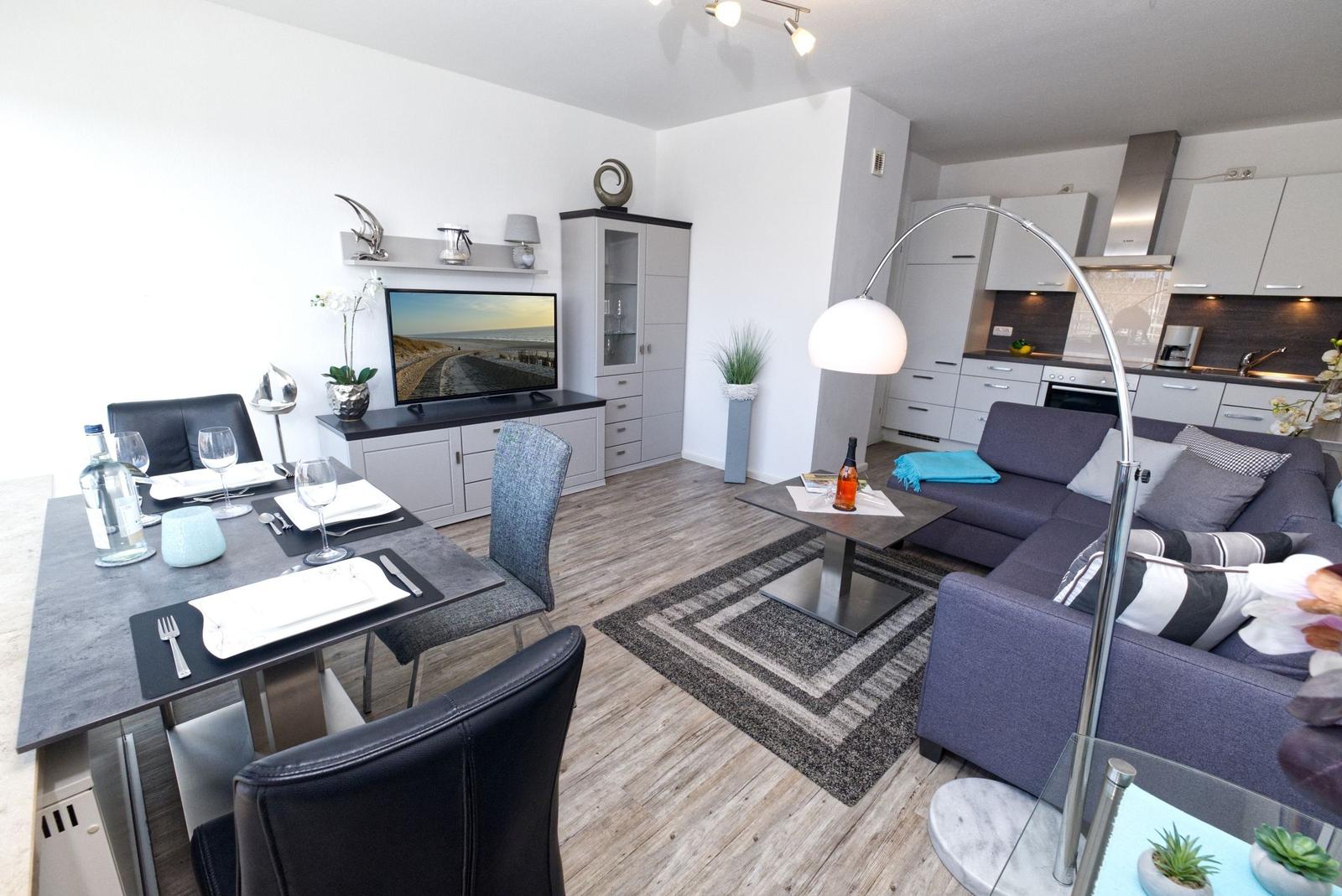 Wohnung mit Essbereich, Wohnzimmer und Küche. Sofa, Esstisch und TV sichtbar.