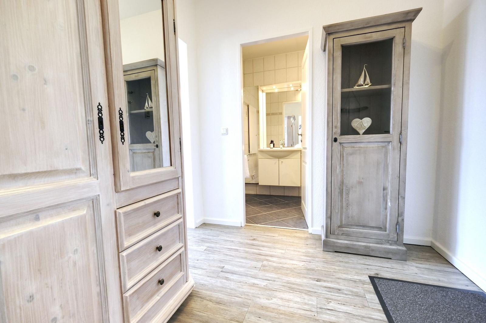 Flur mit Schrank und Blick in die Badewanne.