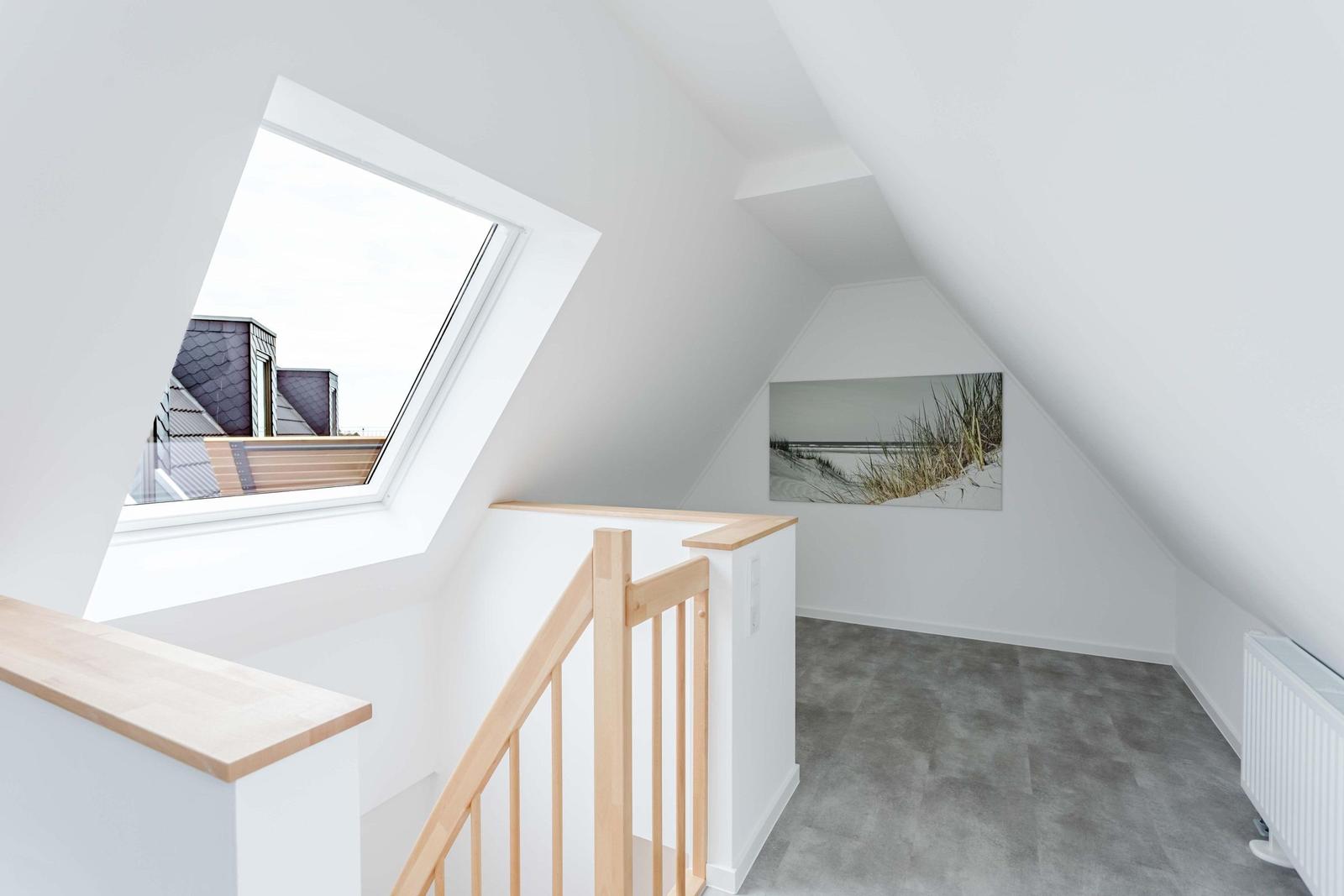 Dachgeschoss mit Holzgeländer, Dachfenster und Wandbild.