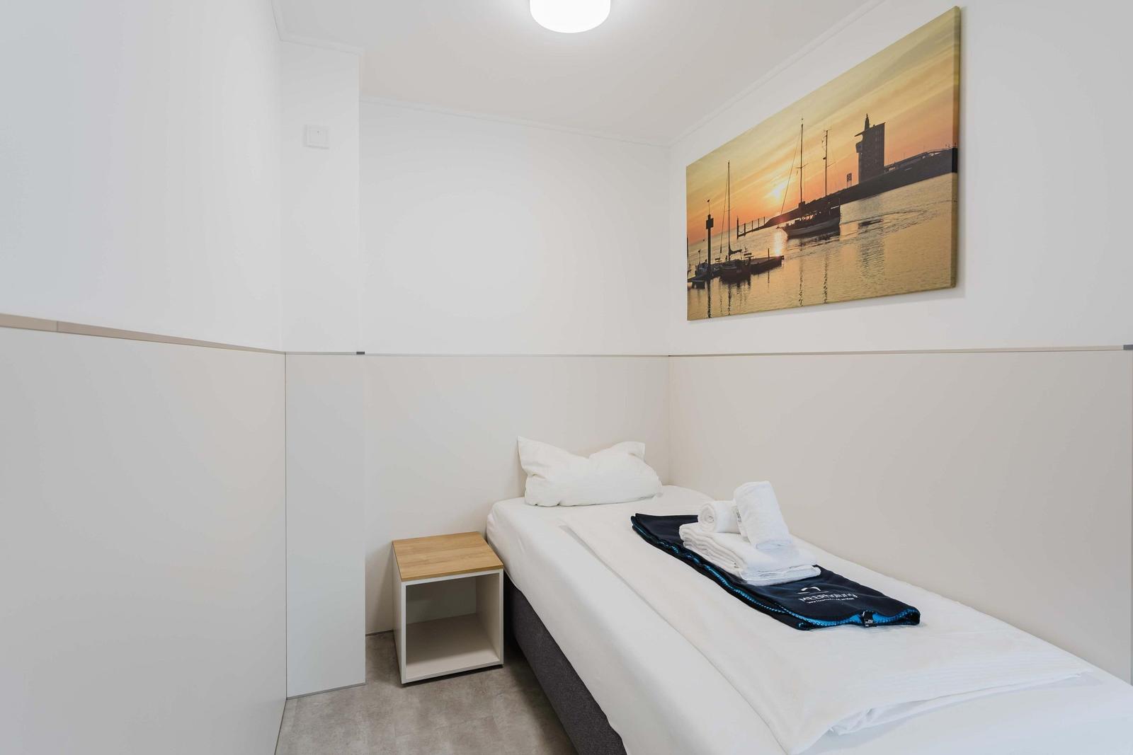 Ein Schlafzimmer mit einem Bett, einem Nachttisch und einem Wandbild.