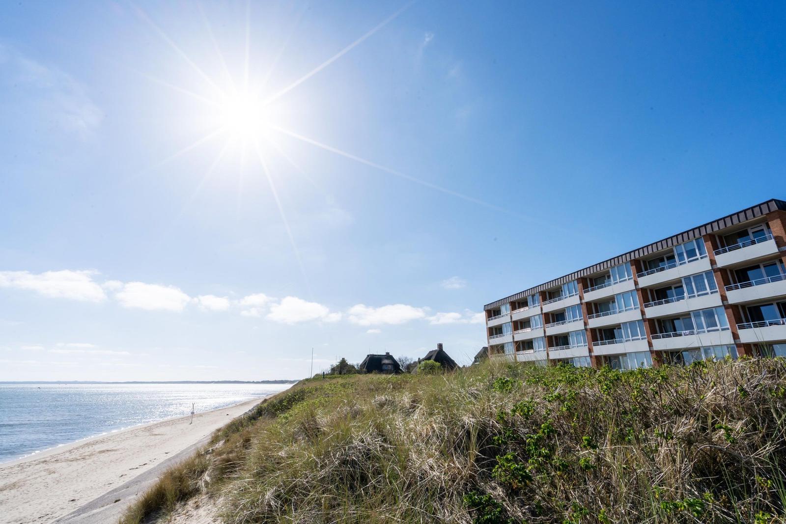 Beach house with sea view under blue sky.