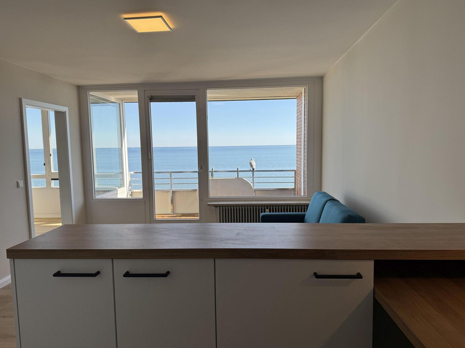 Apartment with kitchen island and sea view from balcony