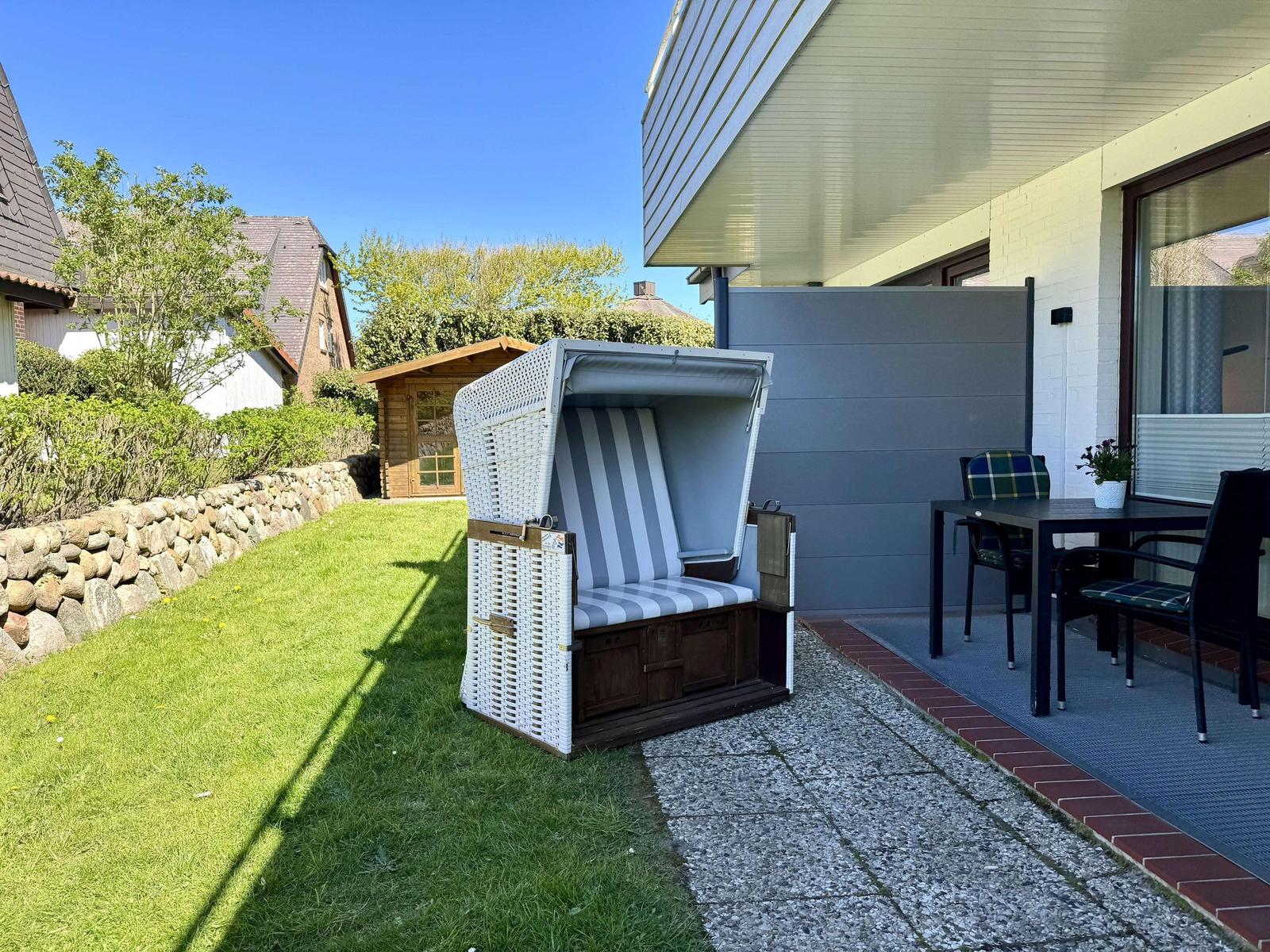 Außenbereich mit Strandkorb, Tisch und Stühlen auf Terrasse