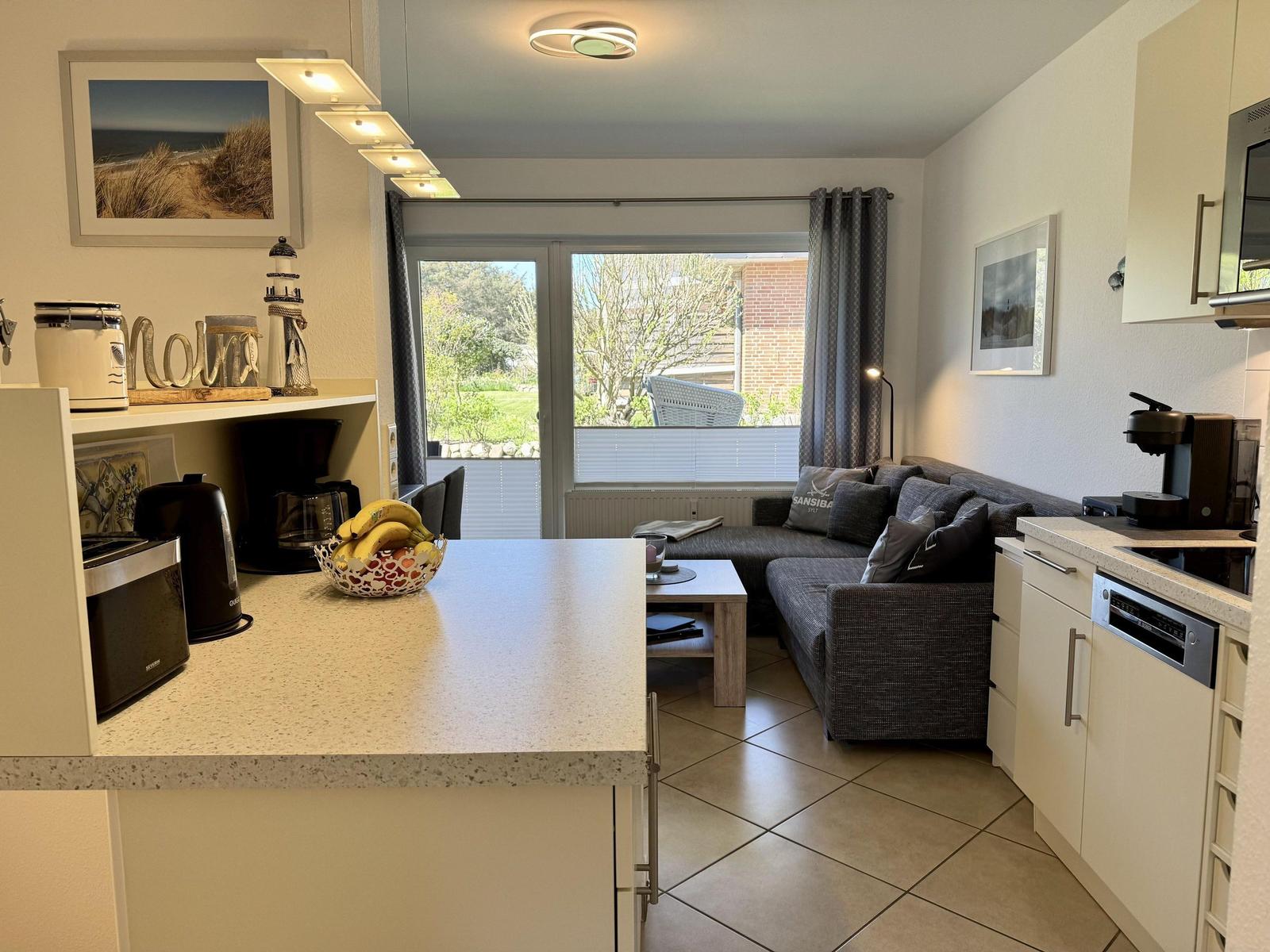 Küche mit Essbereich und Wohnbereich mit Sofa und Fenster