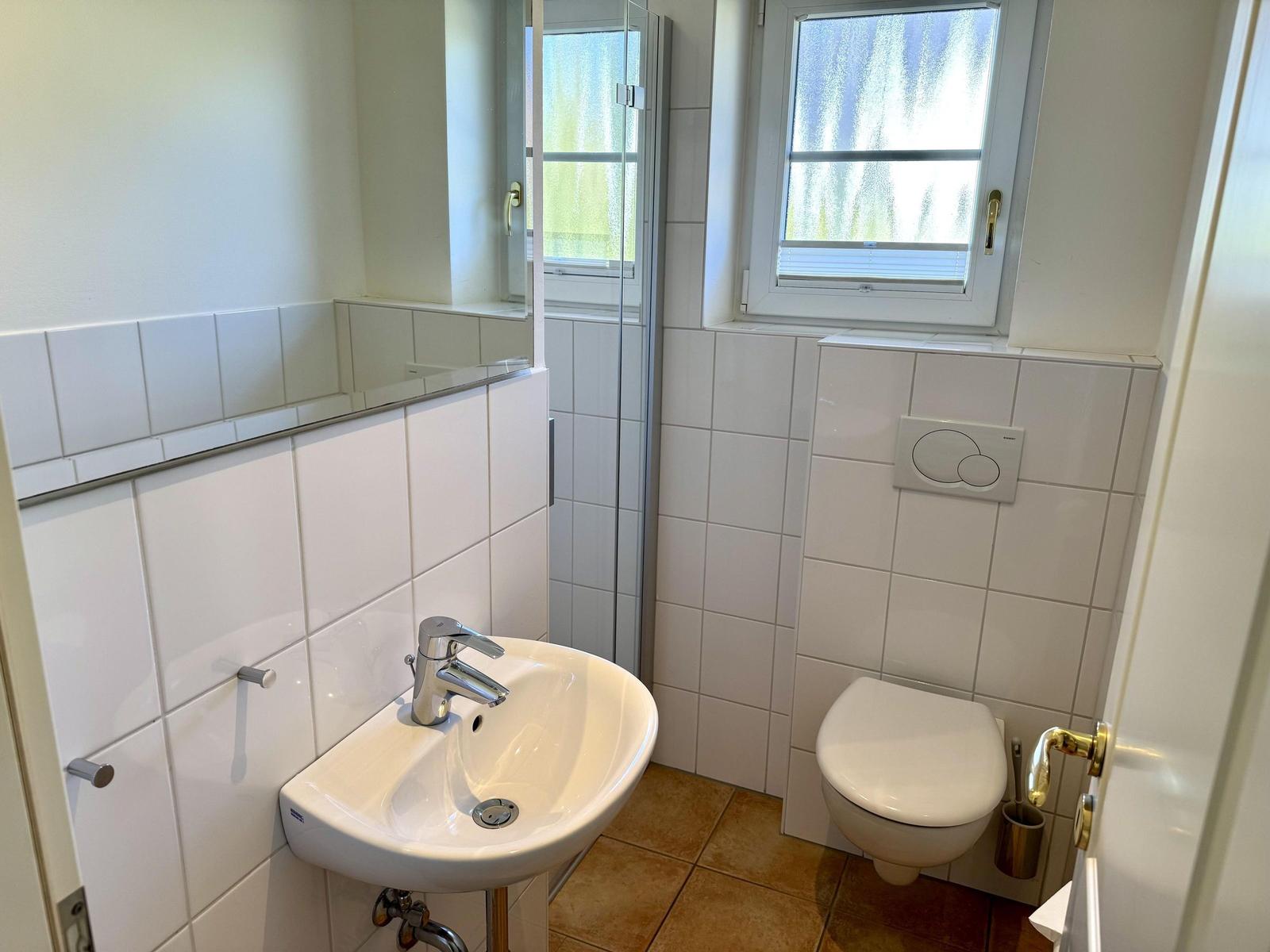 Badezimmer mit Waschbecken, Toilette und Dusche.