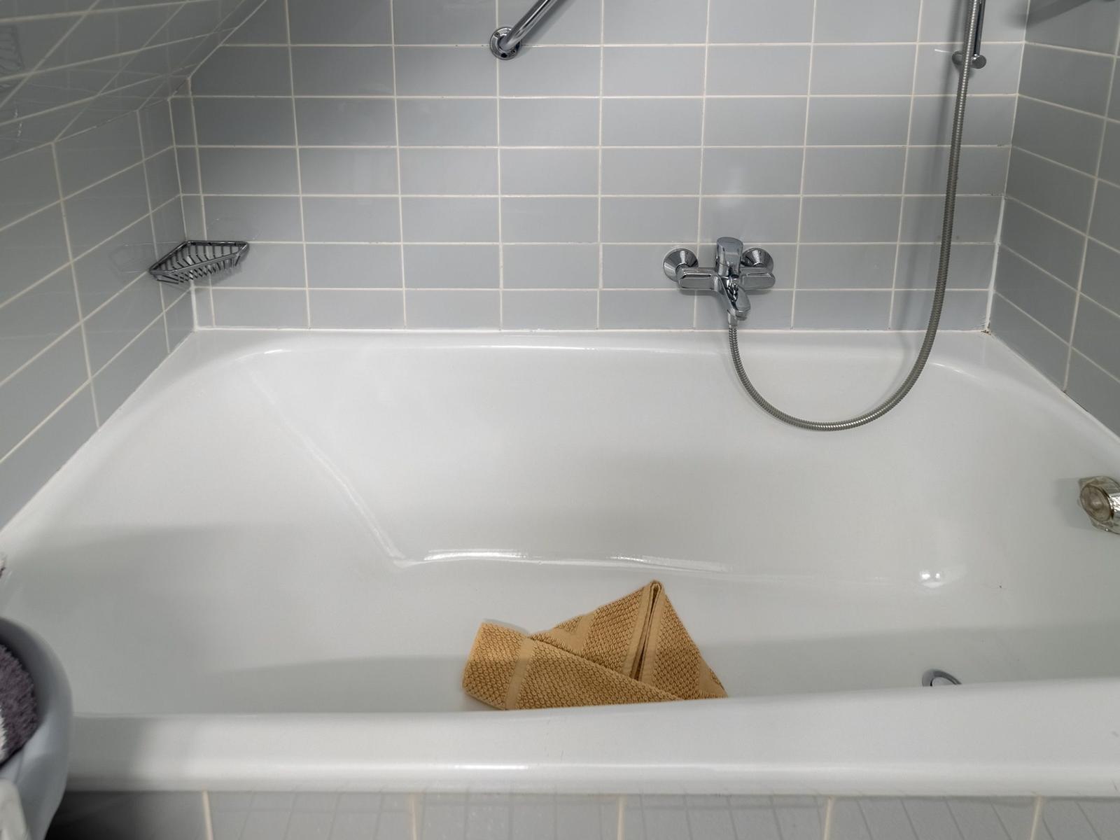 Badewanne mit Duschbrause und Handtuch