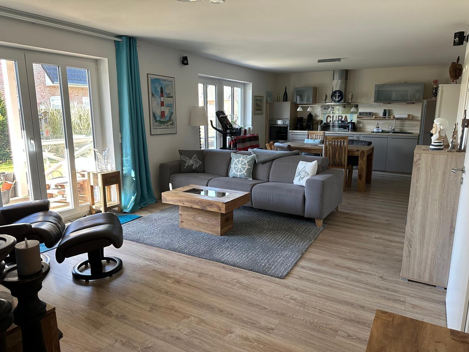 Wohn- und Küchenbereich mit Sofa, Tisch und Fenster zur Terrasse.