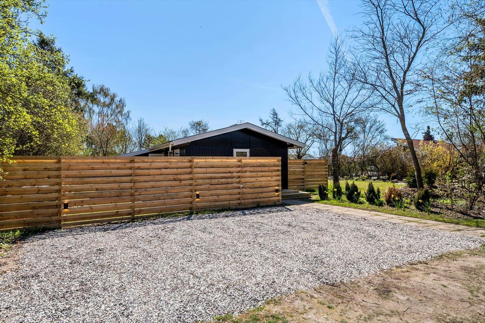 Modern cabin with wooden fence and gravel area in the garden