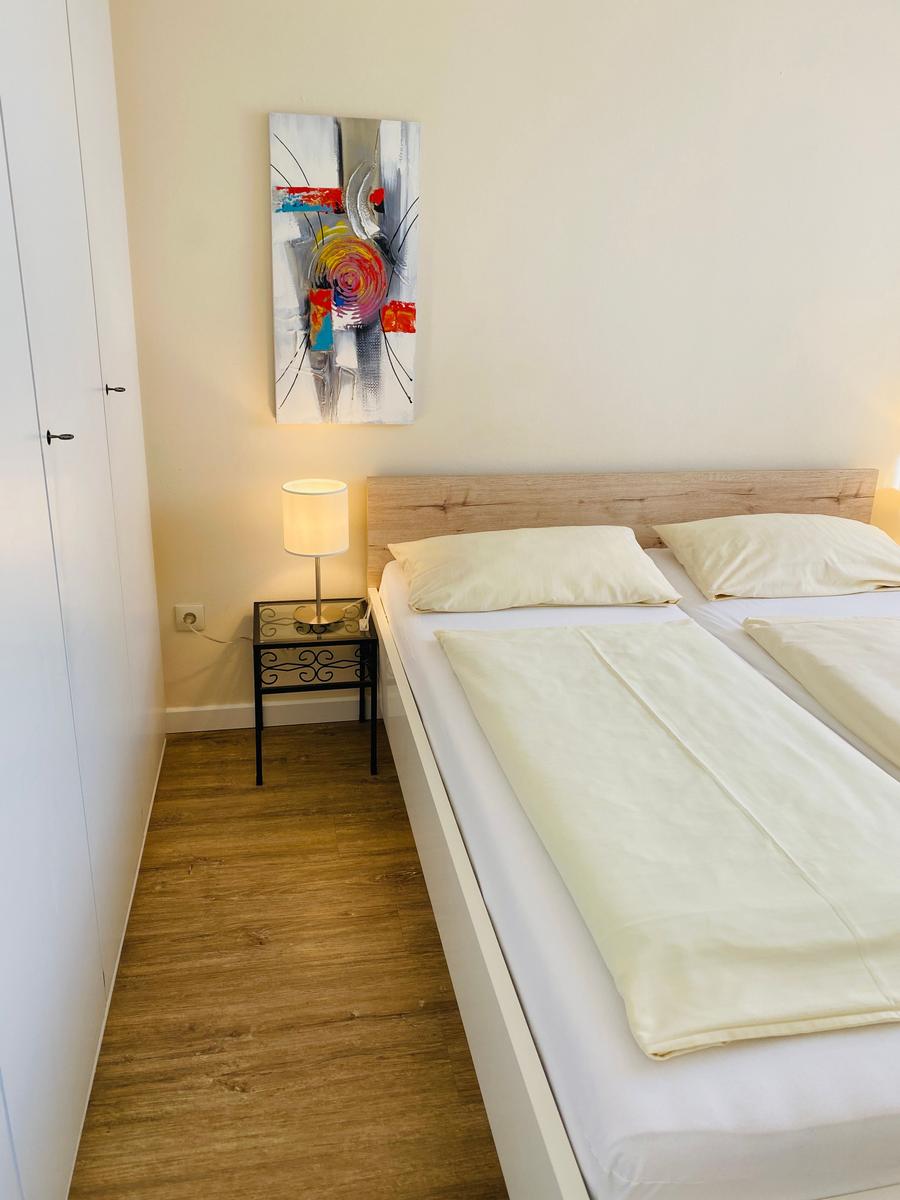 Schlafzimmer mit Bett, Nachttisch und Wandbild
