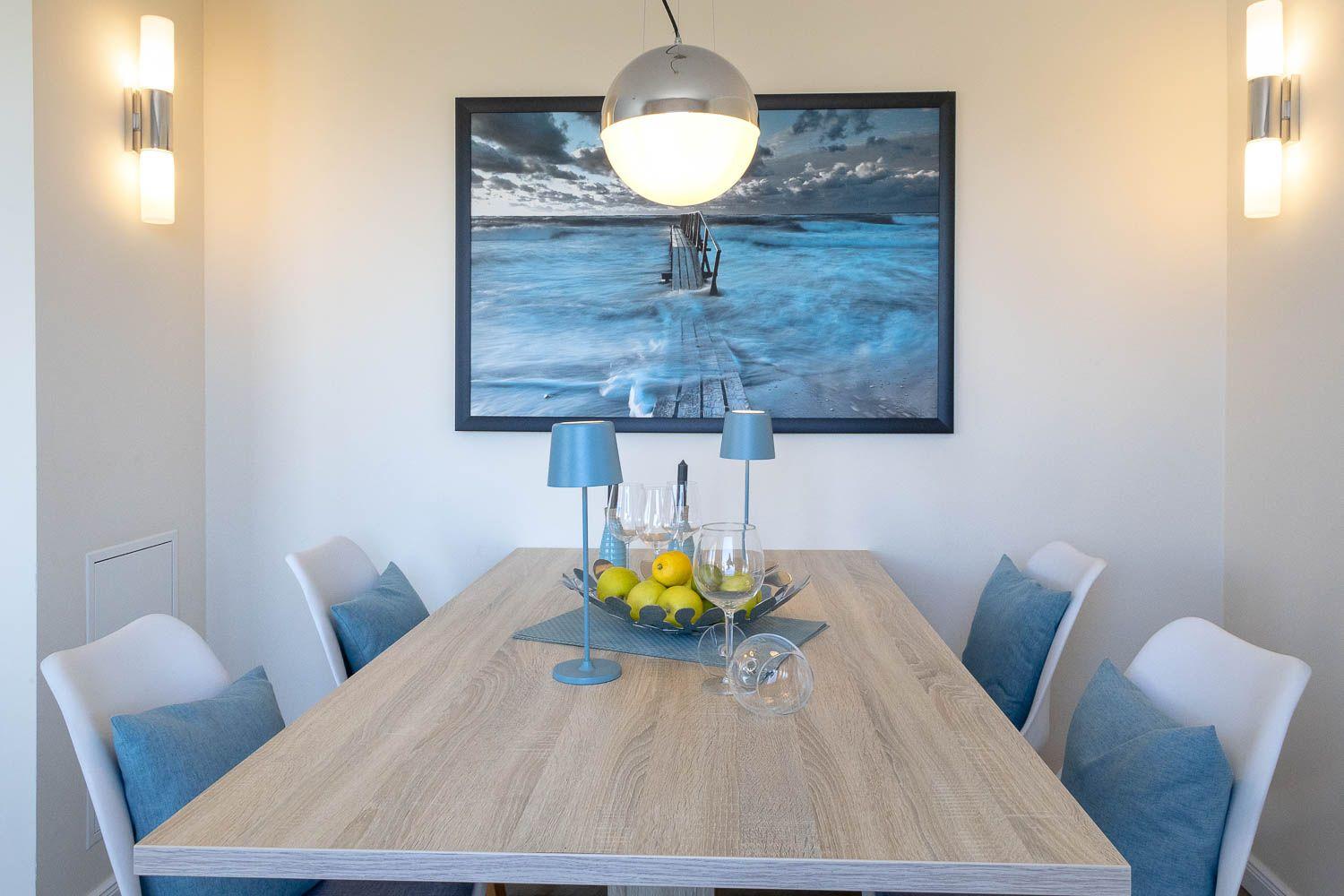 Esszimmer mit Holztisch, Stühlen und Wandbild an der Wand.