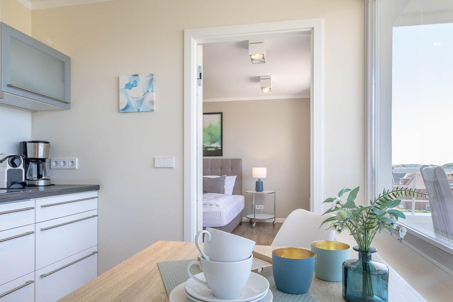 Küche mit Essbereich und Blick in Schlafzimmer. Fenster mit Blick auf Dächer.