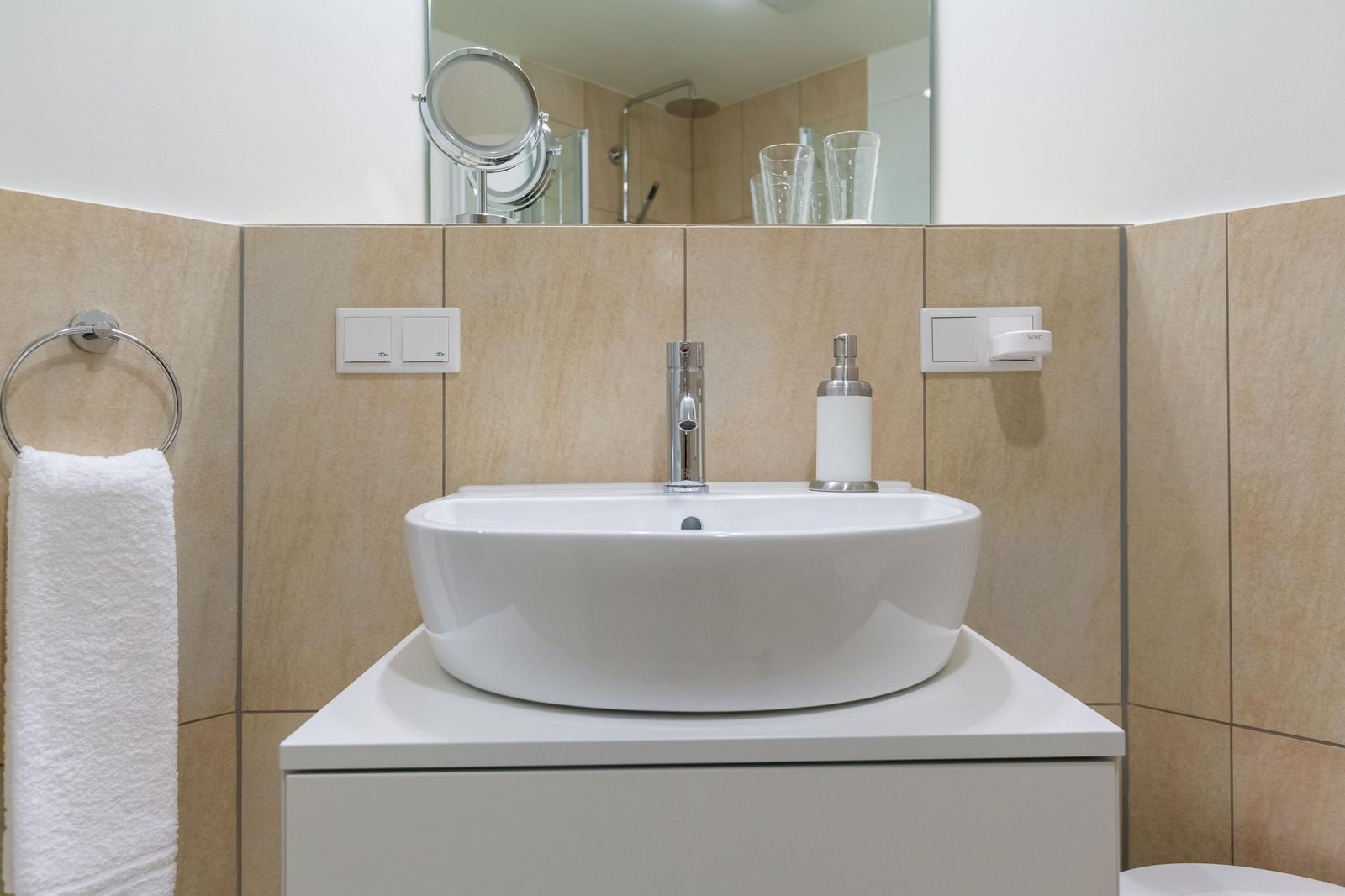 Waschbecken mit Spiegel und Handtuchhalter an der Wand