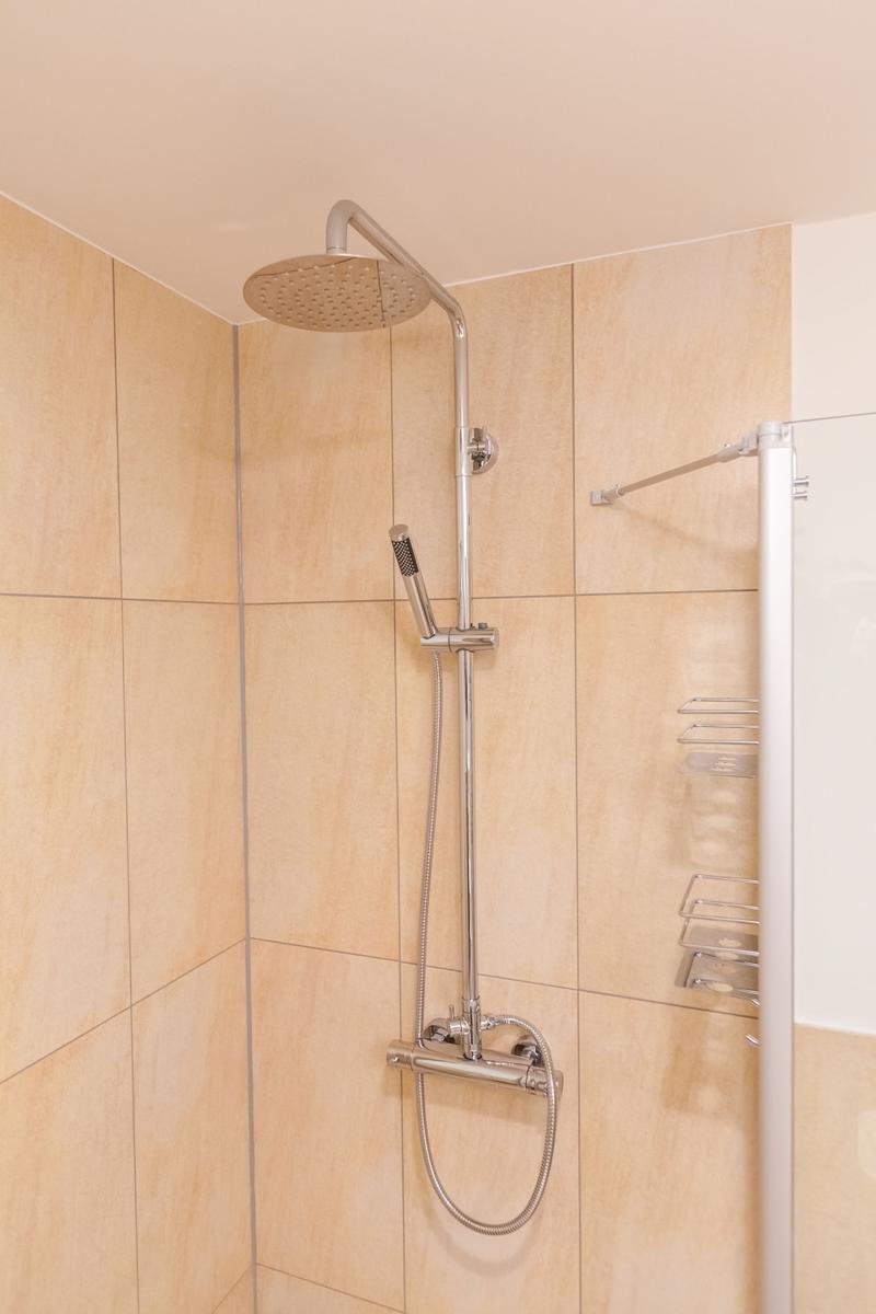 Dusche mit Duschbrause und Handbrause an Wand montiert