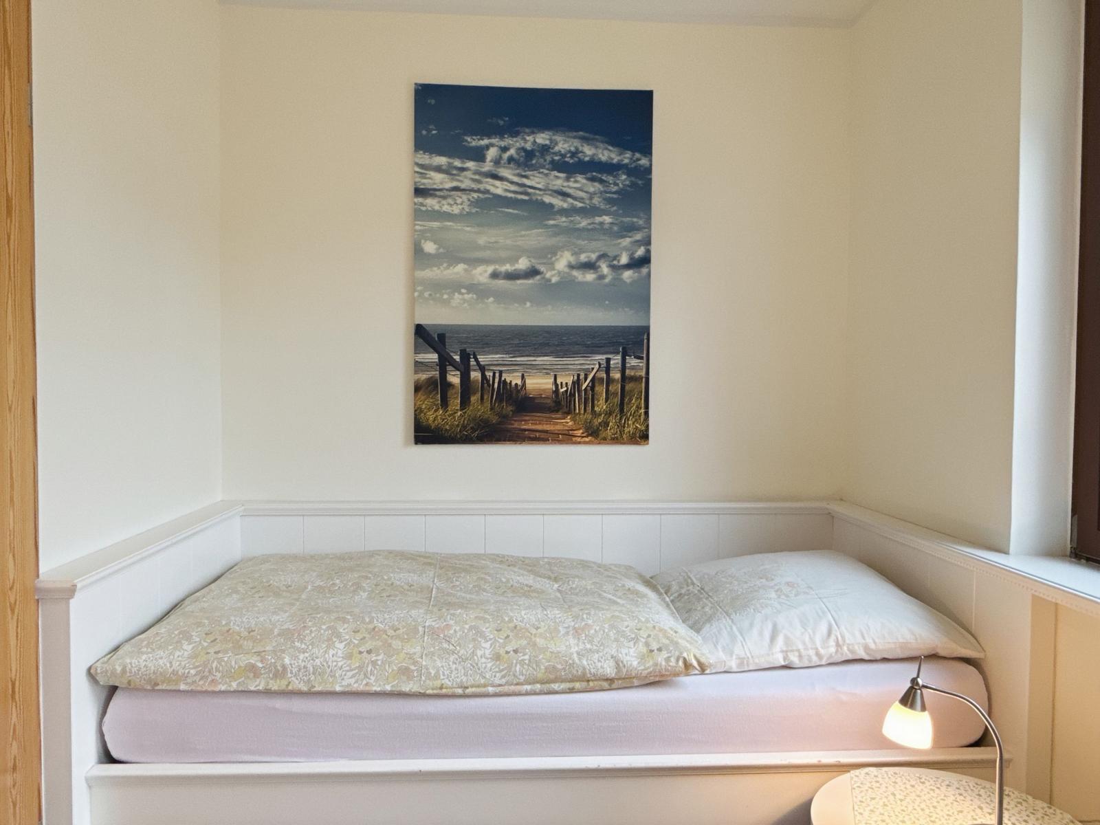 Bedroom with bed and wall picture on the wall
