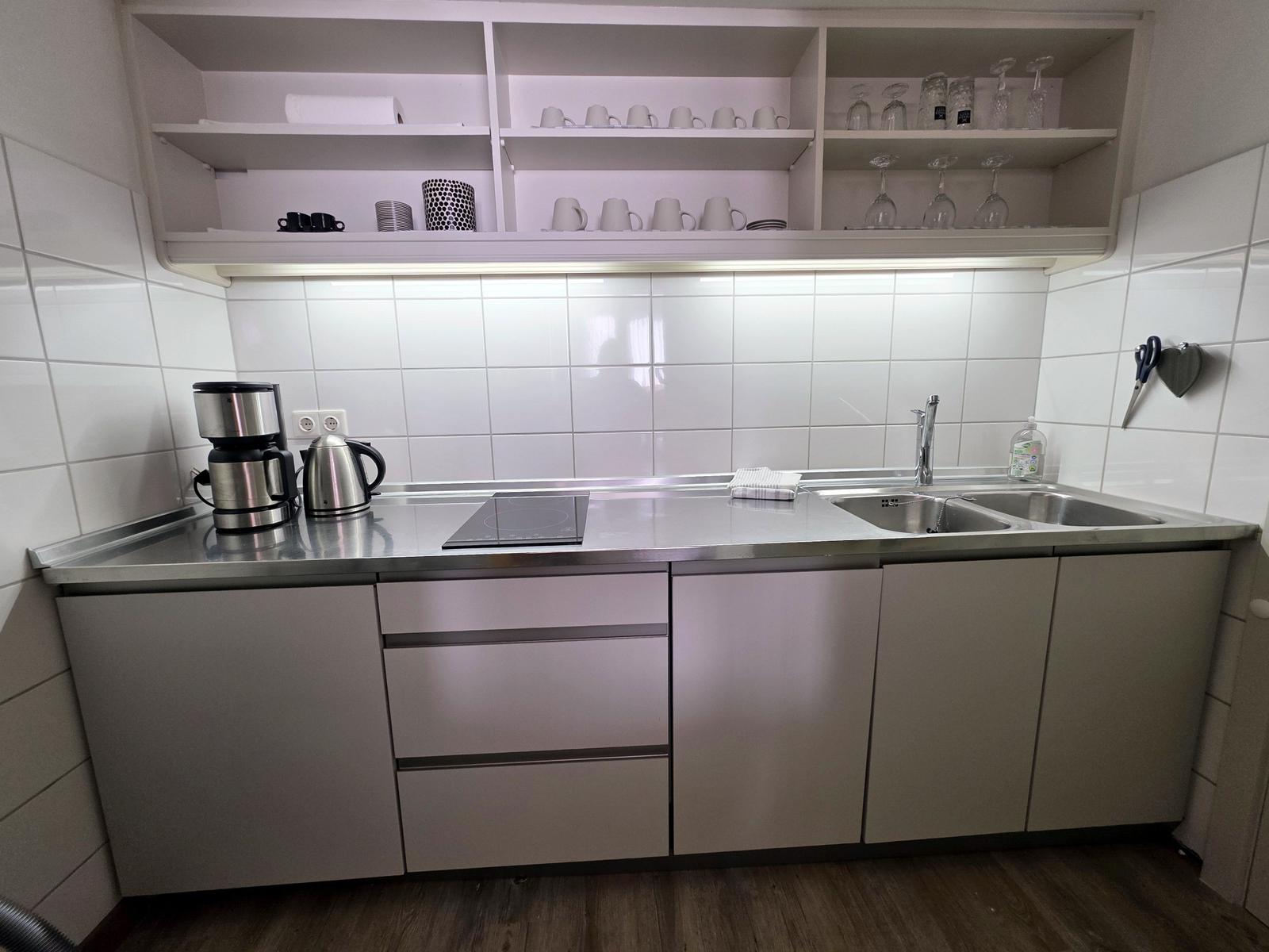 Neue Küche mit Ceranfeld, Spülmaschine, Kühlschrank mit Eisfach, Wasserkocher, Toaster und Nespressomaschine.