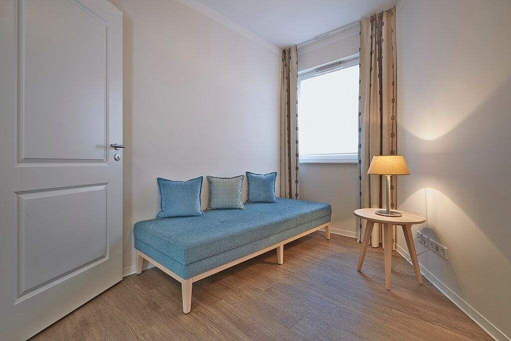 Wohn- und Essbereich mit Sofa, Tisch und Küche.