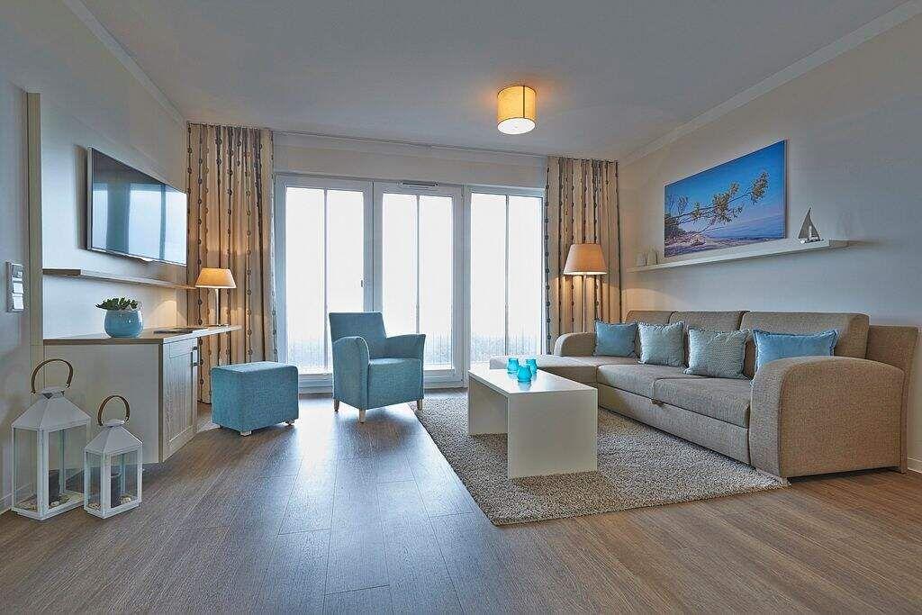 Wohnzimmer mit Sofa, Sitzgelegenheit und Blick aufs Meer.