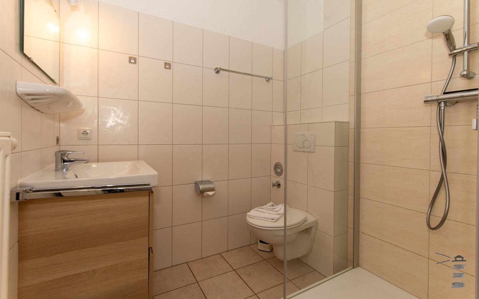 Badezimmer mit Dusche, Toilette und Waschbecken