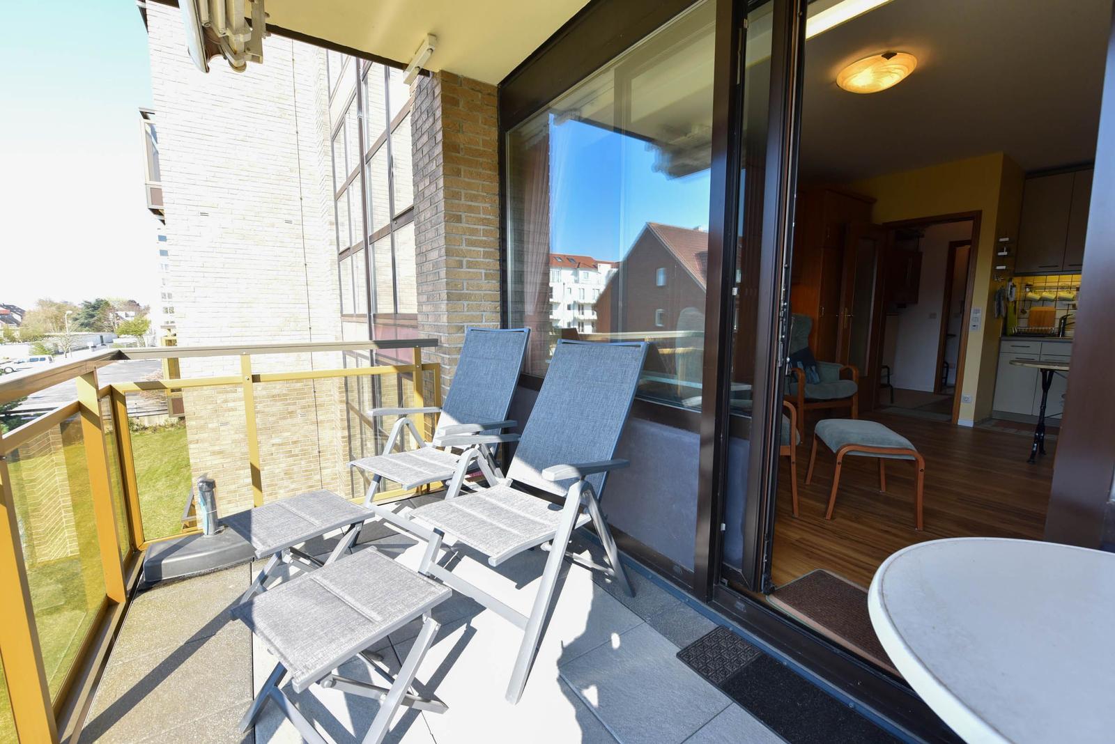 Terrasse mit zwei Liegestühlen und Blick in das Wohnzimmer.