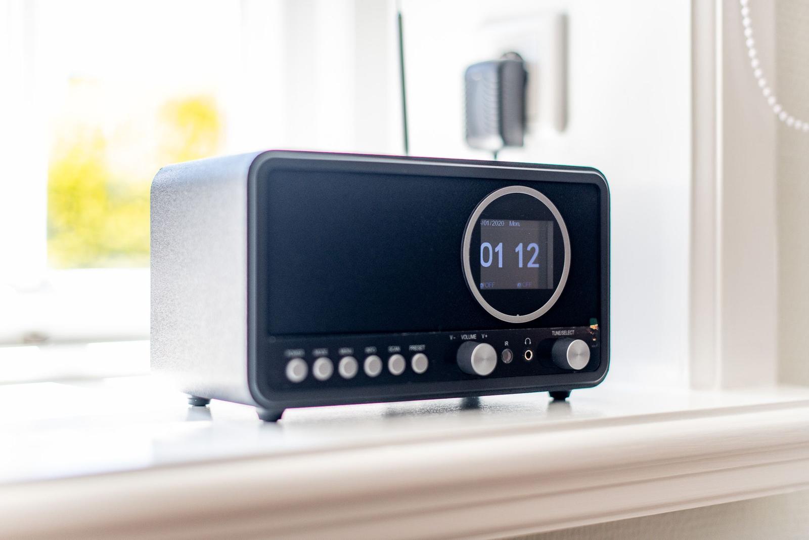 A modern radio receiver sits on a windowsill.