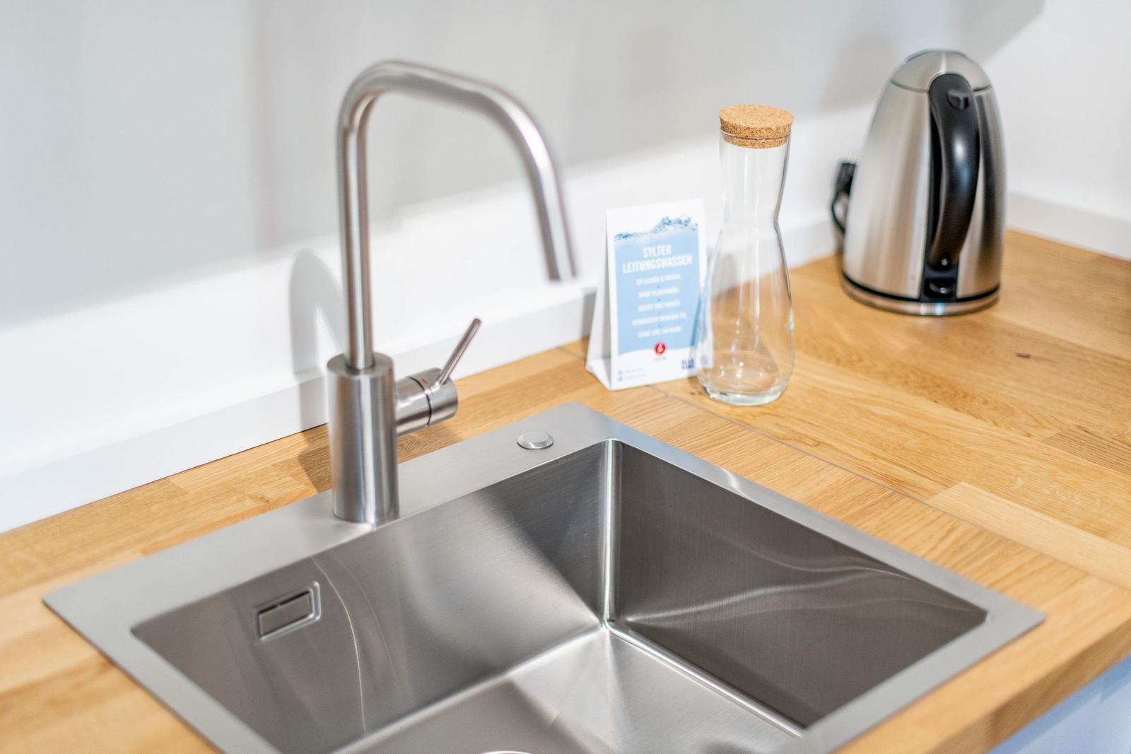 Kitchen worktop with stainless steel sink and modern faucet.
